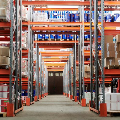 Wide angle view of a warehouse with stocked shelves and boxes.